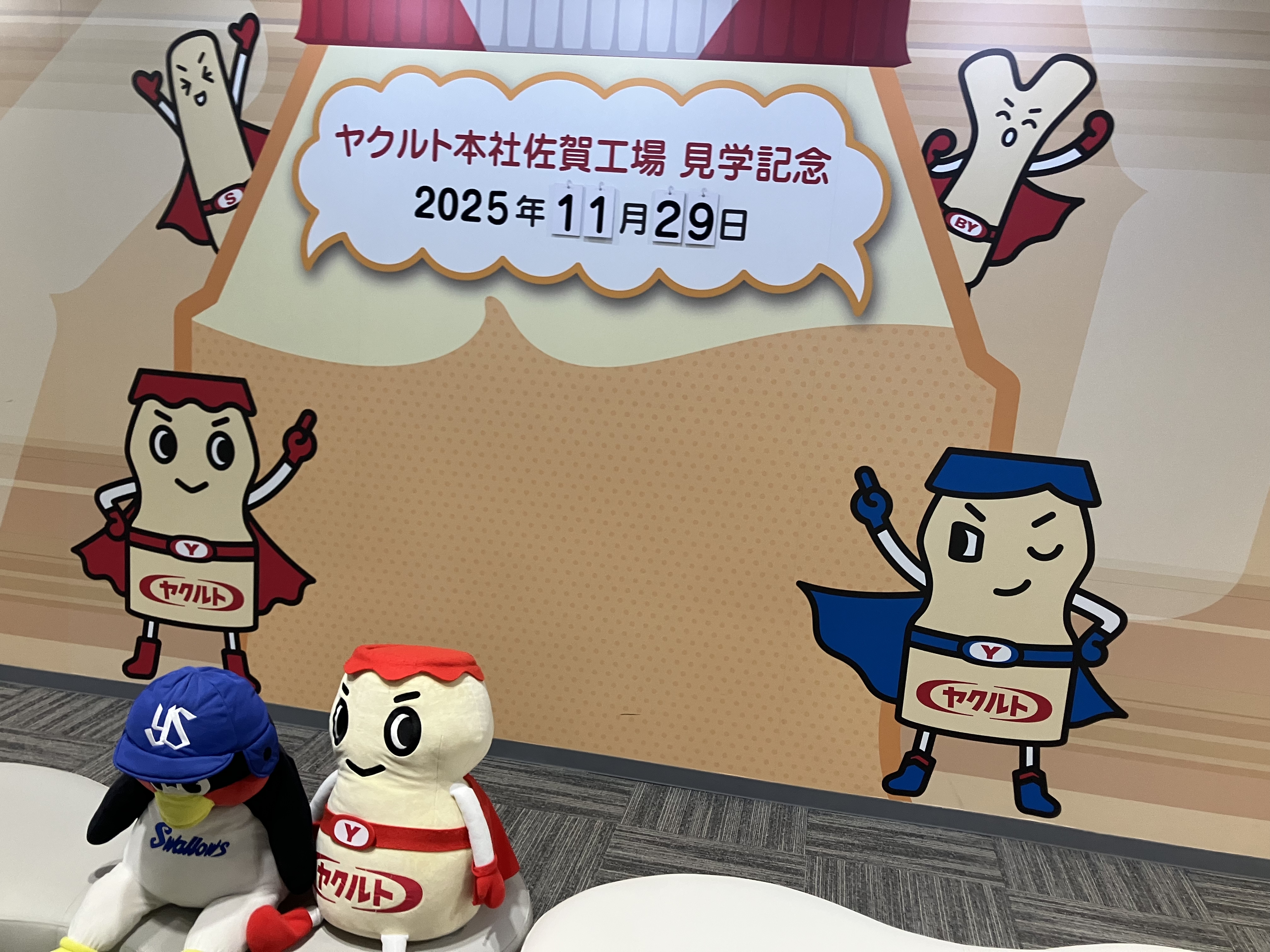 ヤクルトのキャラクターの看板の前で記念撮影